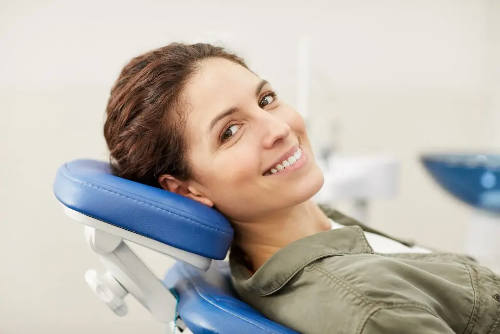 Frau im Zahnarztstuhl, glücklich